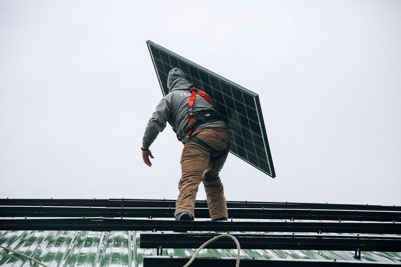 Solar installers working on a rooftop photovoltaic array
